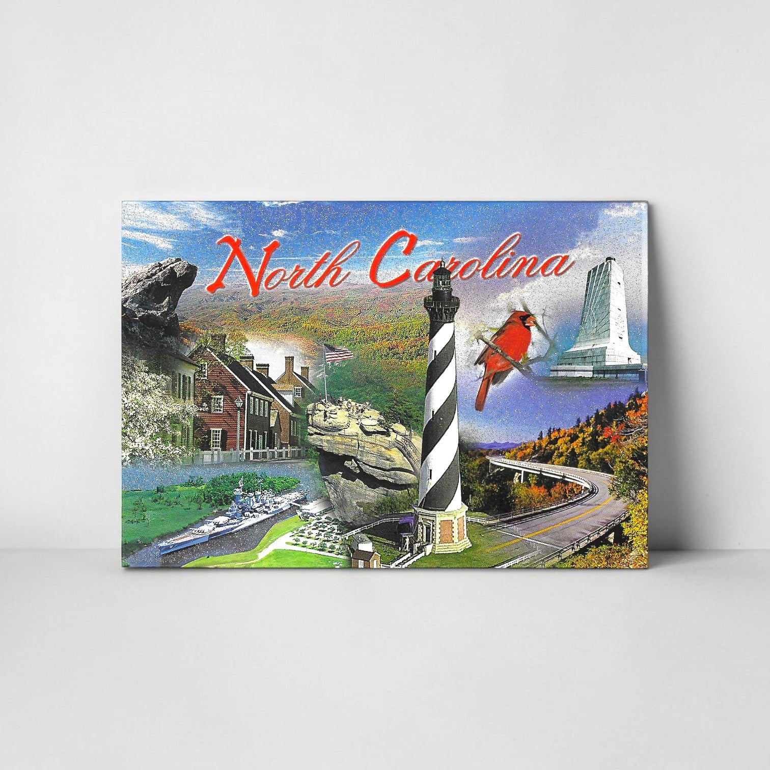 North Carolina postcard with a collage of the landscape with lighthouse, mountains, and buildings on a gray background